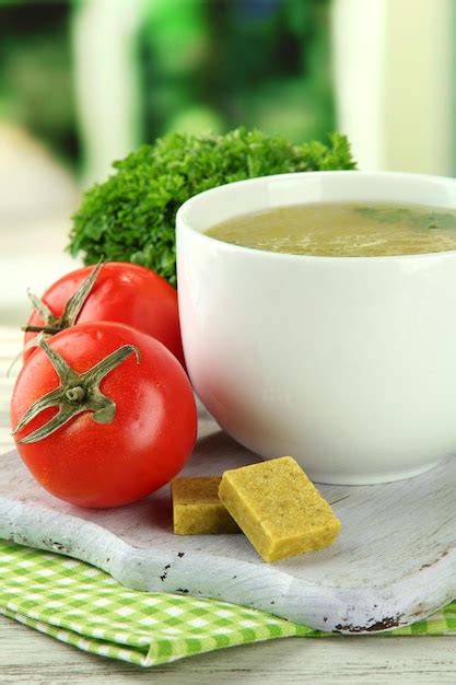 Premium Photo | Cup of soup with bouillon cubes on wooden table