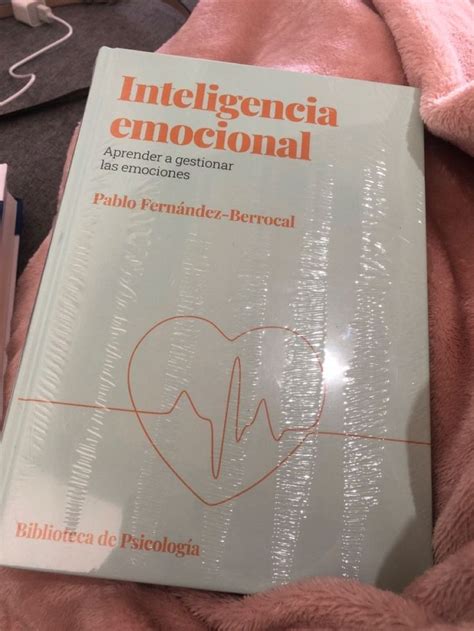 A Book On Intilegencia Enoccional Is Laying On A Pink Blanket