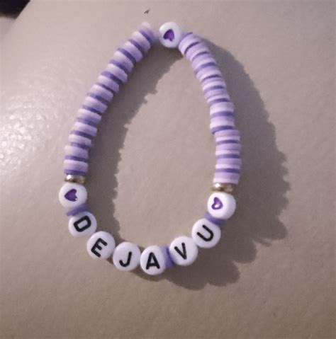 A Purple And White Beaded Bracelet That Says Deja Vu On The End Of It