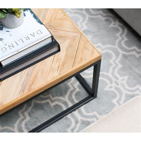 A Coffee Table With A Book On It And A Potted Plant Sitting On Top