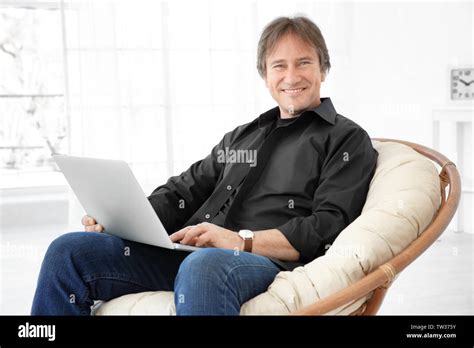 Mature Man Sitting On Chair And Working With Laptop Stock Photo Alamy