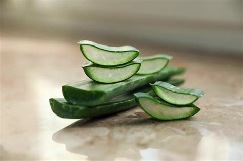 Hojas De Aloe Vera Verde Y Rodajas En El Primer Plano De La Mesa De