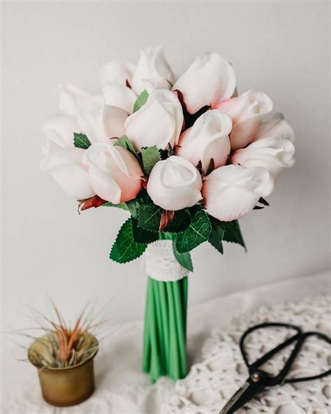 A Bouquet Of White Roses In A Green Vase Next To A Pair Of Scissors