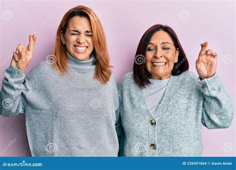 Madre Latina Y Su Hija Vistiendo Ropa Informal Haciendo Gestos Con El Dedo Cruzado Sonriendo Con