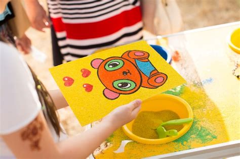 Premium Photo A Child Draws With Colored Sand Picture Cartoon