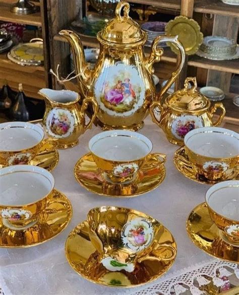 A Table Topped With Gold Dishes And Cups