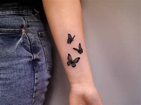 A Woman S Arm With Three Small Butterflies On The Left Side Of Her Arm