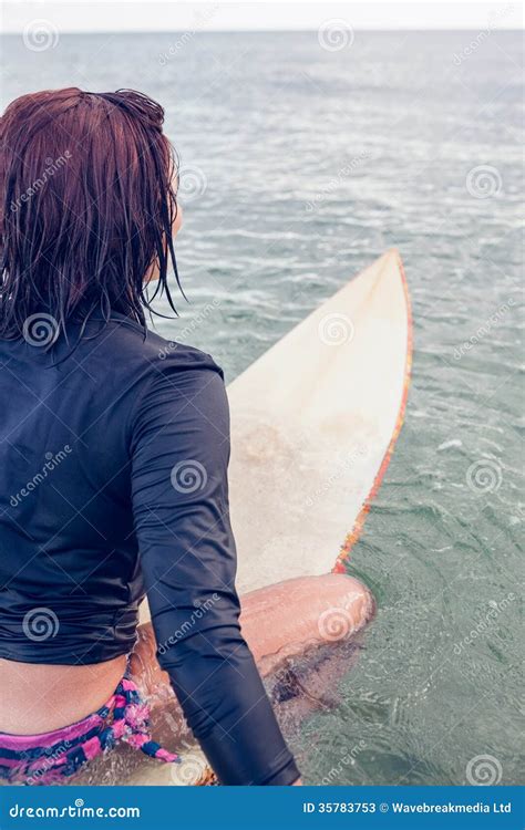 Rear View Of A Woman Sitting On Surfboard In Water Stock Image Image