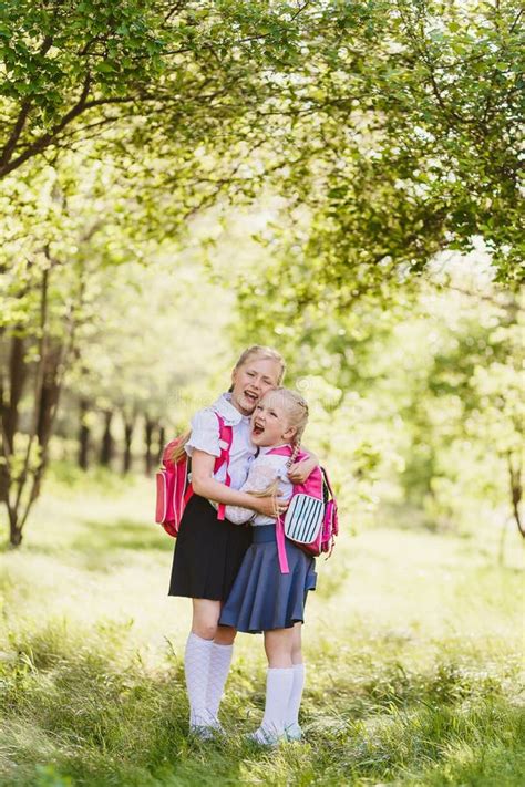 Meninas Louras Bonitos No Aperto Da Farda Da Escola Imagem De Stock