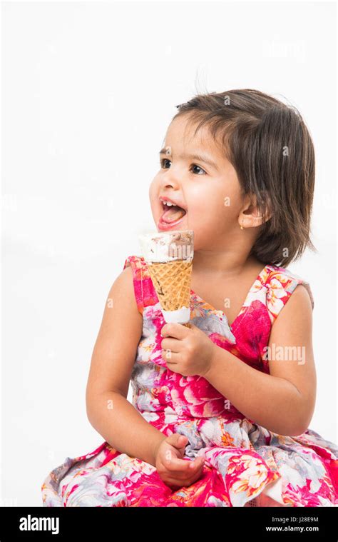 Indian Adorable Bebé O Niña Lamer O Comer Helado De Chocolate En El Cono Cono Y Mostrando