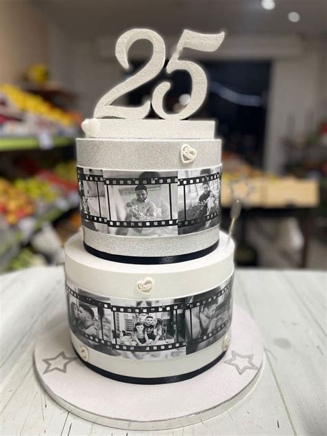 A Three Tiered Cake With The Number Twenty Five On Top And Film Strips