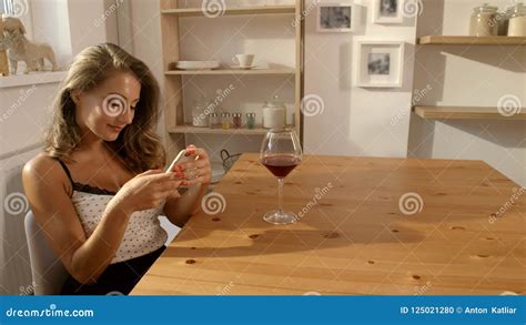 And Attractive Woman In Candid Dress Sits At The Table In A Cafe With