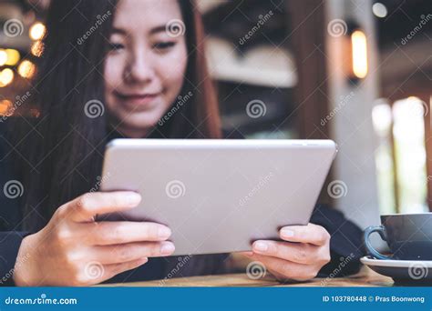 A Beautiful Asian Woman With Smiley Face Using Tablet Stock Photo