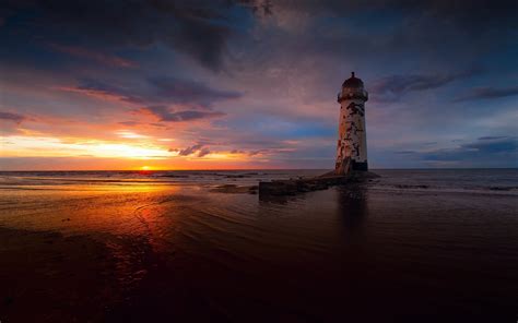 Stunning Lighthouse Sunset Hd Wallpaper Of A Serene Beach Landscape