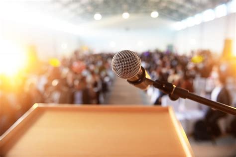 Microphone In Front Of Podium With Crowd In The Background The Tv Coach