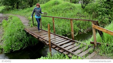 Woman Go Across A L Ittle River On A Wood Bridge Stock video footage ...