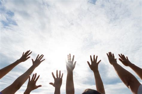 Muitas mãos levantadas contra o céu azul amizade conceito de trabalho