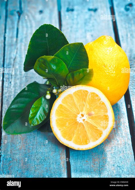 Freshly Cut Half And Whole Lemons With Leaves On Rustic Boards Stock