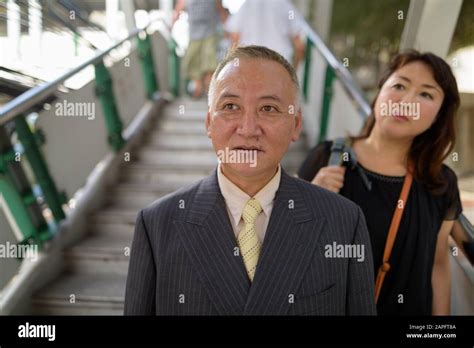 Portrait Of Mature Japanese Businessman And Mature Japanese Woman Exploring The City Of Bangkok