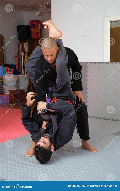 Two Men Practicing Brazilian Jiu Jitsu Sparring At The Academy Stock