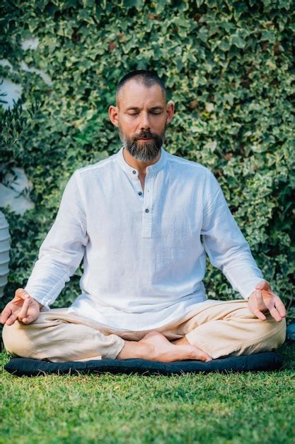 Hombre pacífico meditando sentado en posición de loto Foto Premium