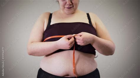 Vidéo Stock Cheerful fat Caucasian girl measuring chest with tape meter