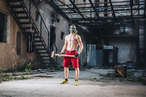 Strong Man With A Sledge Hammer Wearing A Gas Mask Stock Photo