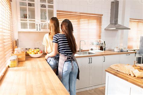 Behind Of Two Girlfriends Or A Lesbian Couple Standing In Kitchen