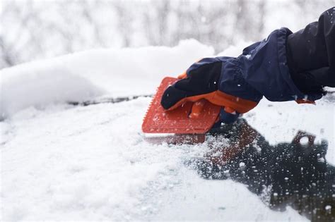 Premium Photo Man Cleans His Car After A Snowfall Cleaning Snow From