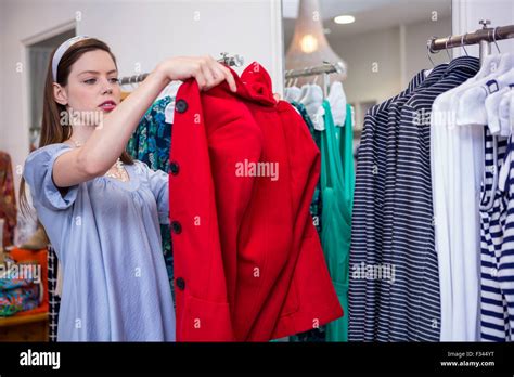 Brunette Trying On A Red Coat Stock Photo Alamy