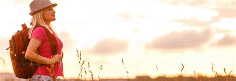 Hipster young girl with backpack enjoying sunset. Tourist traveler on