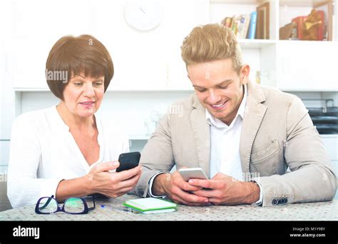 Happy Mature Mother With Her Handsome Son Studing New Functions Of Smartphones Stock Photo Alamy
