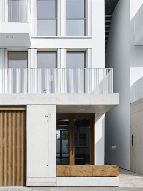 An Apartment Building With White Walls And Wooden Doors