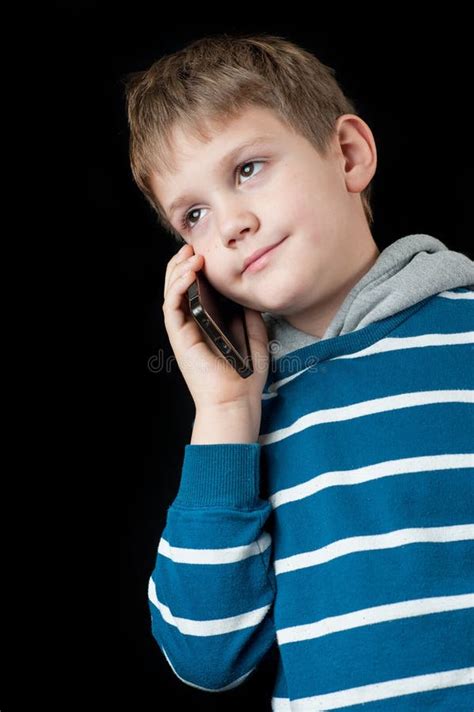 Menino Novo Que Fala No Telefone Celular E No Sorriso Foto De Stock