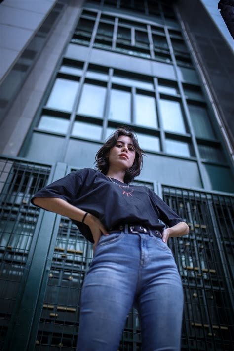 A Woman Standing In Front Of A Tall Building With Her Hands On Her Hips