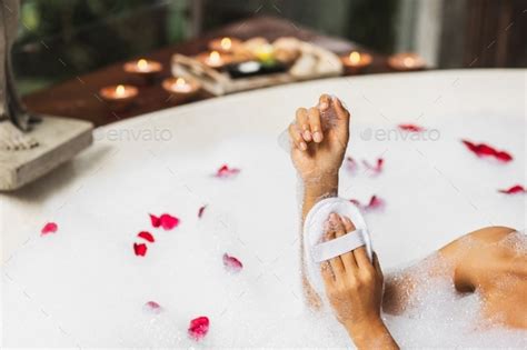 Woman Washing Hands In Bath Tub With Foam Bubbles And Use Jute Sponge