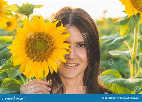 Portrait Of A Young Beautiful Woman In Sunflowers Woman Covers Half Of