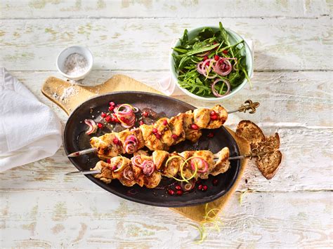 Hähnchen Spieße mit Granatapfel Zwiebel Topping und Rucola Salat