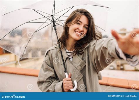 Joyful Young Caucasian Lady Stretches Her Hand To Camera Standing