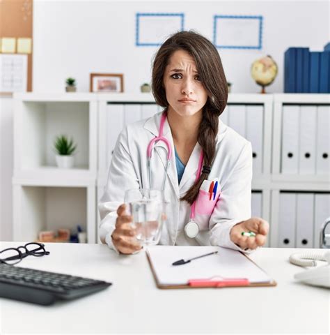 Joven Doctora Sosteniendo Un Vaso De Agua Y Pastillas Recetadas