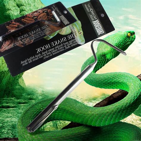 A Green Snake With Its Mouth Open Next To A Pen And Book On Top Of It