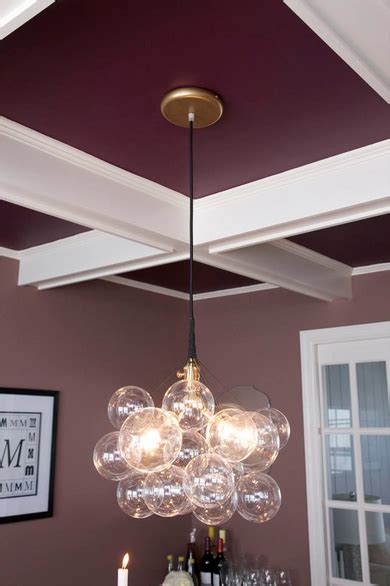 A Custom Light Fixture Hangs Above The Dining Table While A Bold Color