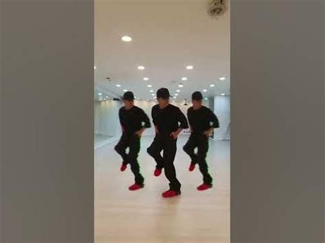 three men in black shirts and red shoes are dancing