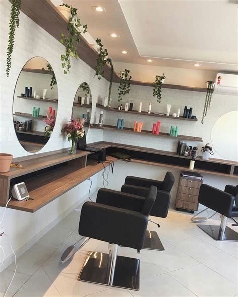 A Hair Salon With Mirrors Chairs And Plants On The Wall Above It S Counter