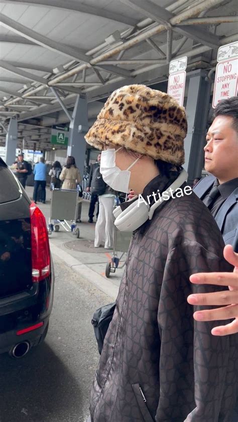 Two People Wearing Face Masks At An Airport