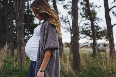 Beautiful Young Mixed Race Pregnant Woman Standing In Forest By