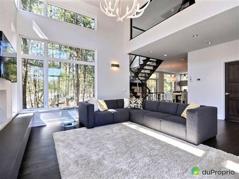 A Living Room With A Large Gray Couch And White Rug On Top Of The Floor