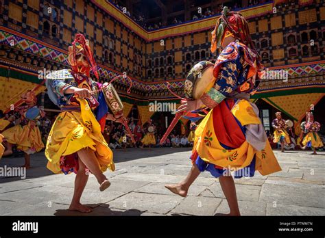 Buddhist Monk Dancing And Holding A Drum At Colourful Mask Dance At