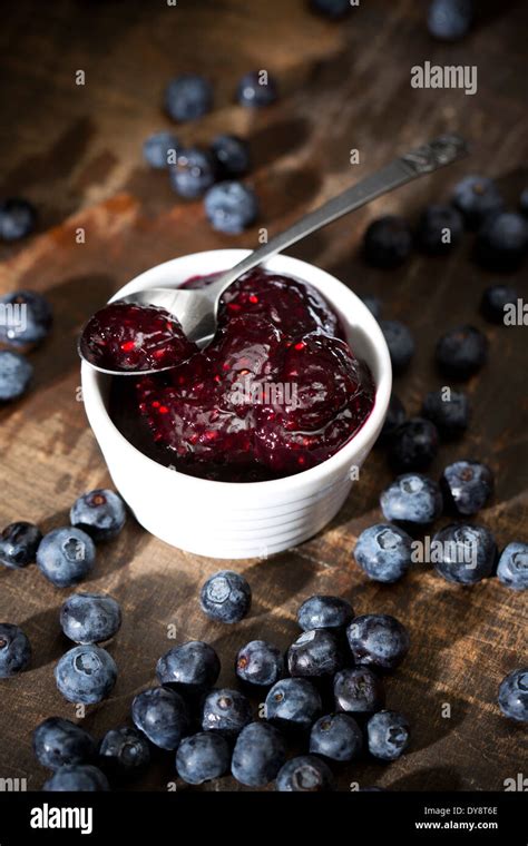 Bowl Of Blueberry And Raspberry Jam Spoon And Blueberries On Dark