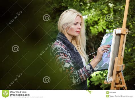 El Artista De La Mujer Con Un Cepillo En Su Mano Dibuja En Lona Foto De